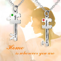 A pair of steel-colored cut letter necklaces.