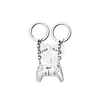 A pair of steel heart-shaped keychains with engraved text.